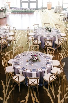 the tables are set up for an elegant wedding reception with blue and white linens