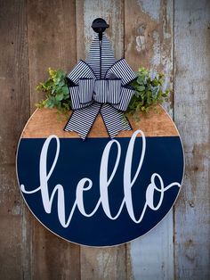 a wooden sign with the word hello painted on it and a planter in front of it