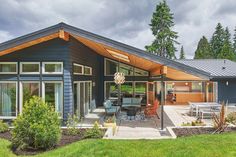 a blue house with a covered patio and picnic table in the front yard on a cloudy day