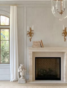 a living room with a fireplace, chandelier and two vases on the table