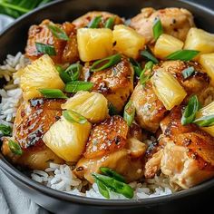 chicken and pineapple stir - fry with rice in a black bowl on a table