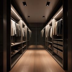 an empty walk in closet with lots of clothes on the shelves and lights above it