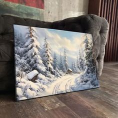 a painting sitting on top of a wooden floor in front of a couch and chair