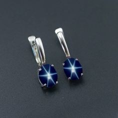 This Earrings Features a 6X8 MM Oval Cabochon Natural Lindy Star and Sterling Silver Finished with rhodium. Customization is available. It is made by hand, and it will take about 3 to 5 business days to finish the ring after your payment is completed. Product Description Main stone: Natural Blue Lindy Star Metal type: 92.5 Sterling Silver finished with rhodium How To take care of This Earrings - Keep the jewelry away from direct heat, water, perfumes, deodorants, and other strong chemicals. Wipe Blue Star-shaped Sterling Silver Earrings, Blue Sterling Silver Star Earrings, Silver Prices, Star Ring, Blue Star, Oval Cabochon, Star Earrings, Deodorant, Gemstone Earrings