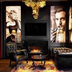 a living room filled with black furniture and paintings