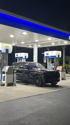 a black car is parked at a gas station