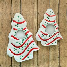 two christmas tree shaped cookie cutters sitting on top of a wooden table