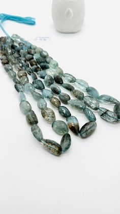 a group of beads sitting on top of a white table next to a blue string