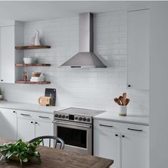 a kitchen with an oven, stove and table in front of the counter top is white