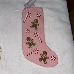 a pink christmas stocking with gingerbreads and candy canes