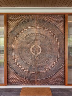 a large metal door on the side of a building with glass doors and wood trimmings