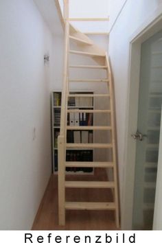 there is a wooden staircase going up to the top floor in this room with bookshelves