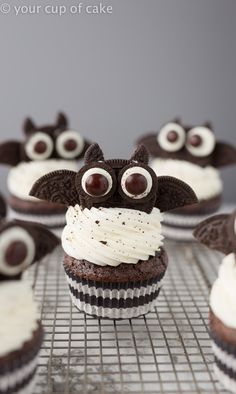 chocolate cupcakes with white frosting and decorated eyes on a cooling wire rack