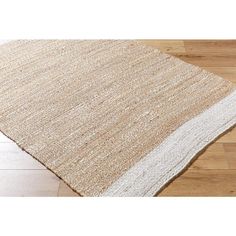 a beige and white rug on top of a wooden floor