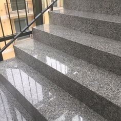 the stairs are made of granite and have glass balconies