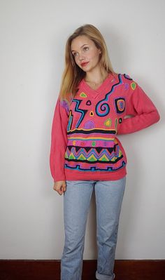 "What a fun funky bright sweater! Definitely a statement piece- bright pink and a great silhouette then the crazy print. The print is upraised and textured making it even cooler. This is tagged an xs but feel it too be closer to a modern medium. There are no flaws to note, in great shape. Measurements are taken flat and doubled where needed. Pit to pit: Waist: Length: Sleeves: Model is 5'5\" and usually a small for reference. Dopey Dog Vintage is a resale shop. While my dog Bandit is present in my home, items are stored away from him. If an allergy is a concern and you are interested in an item- please reach out as I would be happy to work with you. All of the items sold have been worn/used, I aim to pick out items in good to excellent condition and aim to be transparent about any flaws or Colorful Trendy Winter Tops, Trendy Colorful Winter Tops, Playful Fitted Winter Sweater, Playful Fitted Sweater For Winter, Playful Pink Cotton Sweater, Pink Graphic Print Sweater For Fall, Pink Long Sleeve Sweater With Graphic Print, Pink Graphic Print Fall Sweater, Pink Cotton Trendy Sweater