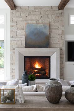 a living room filled with furniture and a fire place under a painting on the wall