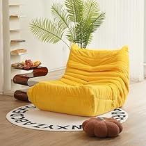 a yellow bean bag chair sitting on top of a wooden floor next to a potted plant