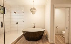 a large bath tub sitting in the middle of a bathroom next to a walk in shower