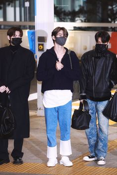 three men wearing face masks at an airport