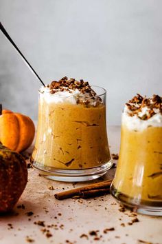 two desserts in small glass dishes with cinnamon sticks sticking out of the top one