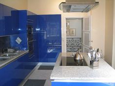 a kitchen with blue cabinets and stainless steel appliances