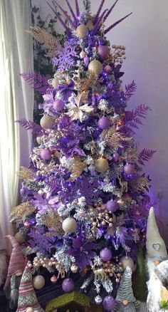 a purple christmas tree decorated with ornaments