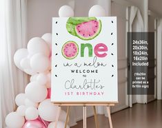 a watermelon themed birthday sign with balloons in the background