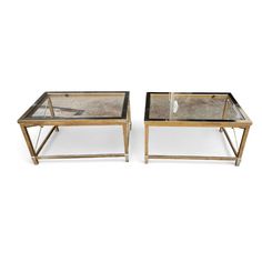 a pair of coffee tables with glass top and metal legs, each side by side