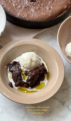 two plates with ice cream and chocolate cake in the middle, on a marble table