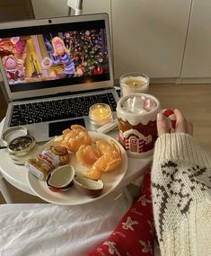 a person sitting in front of a laptop with food on it