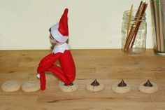 an elf is sitting on his knees in front of cookies