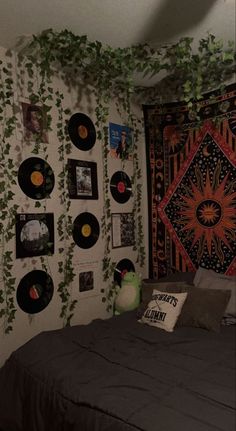 a bed room with a neatly made bed and lots of records on the wall