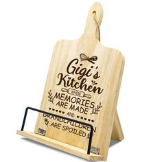 a wooden cutting board with an engraved sign on it's side and the words gigi's kitchen written in cursive writing