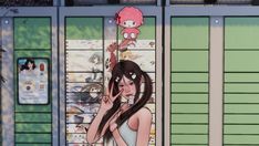 a woman standing in front of a window with an anime character on it's side