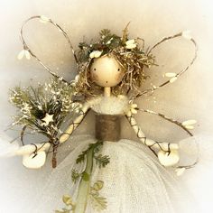 a doll with flowers on her head and branches in her hair is surrounded by white balls