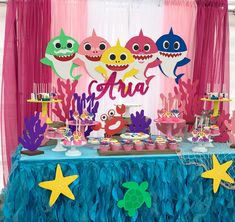 an under the sea themed birthday party with shark decorations and desserts on a table