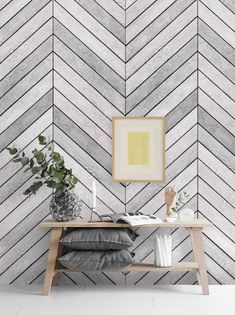 a white and grey herringbone wallpaper with a wooden table in front of it