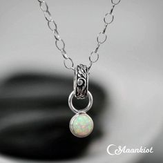 This dainty nature-inspired Silver Opal Pendant Necklace features a 6 mm cabochon gemstone (approx. 1.25 cts.), shown here in man-made Opal. The stone hangs from a loop of tendril and vine patterned Sterling Silver, suspended on an oval link chain with a lobster claw clasp. This modern single stone pendant makes a wonderful gift for you or your special someone! Sterling Silver Drop Pendant with 6 mm cabochon stone, Sterling Silver Oval Link Chain and Clasp Dimensions: Chain length - Your Choice, Bridal Pendant Necklace, Dainty Opal Necklace, Opal Necklace Silver, Bridal Pendant, Vine Pattern, Layered Necklaces Silver, Wedding Pendant, Opal Pendant Necklace, Birthstone Pendant