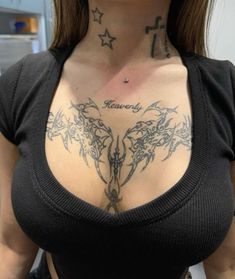 a woman with tattoos on her chest posing for the camera