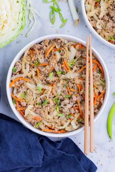 two bowls filled with meat and vegetables next to chopsticks