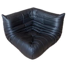 a black leather futon is shown in front of a white background with the bottom section folded down