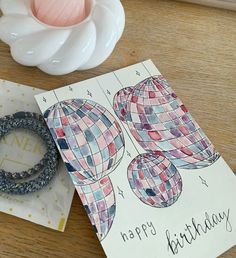 a happy birthday card with two hot air balloons on it and a rubber ring next to it