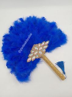 a blue feather fan with a gold handle