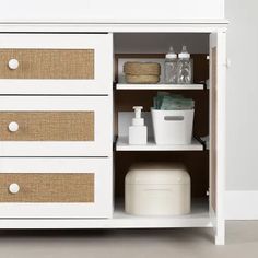 a white cabinet with drawers and baskets on the bottom shelf is shown in this image