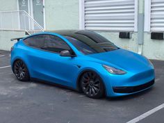 a blue electric car parked in a parking lot