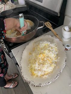 the woman is cooking on the stove in the kitchen