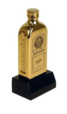 a gold colored liquor bottle sitting on top of a black base