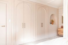 a bedroom with white closets and an arched doorway