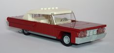 a red and white lego car with the hood up on it's flatbed